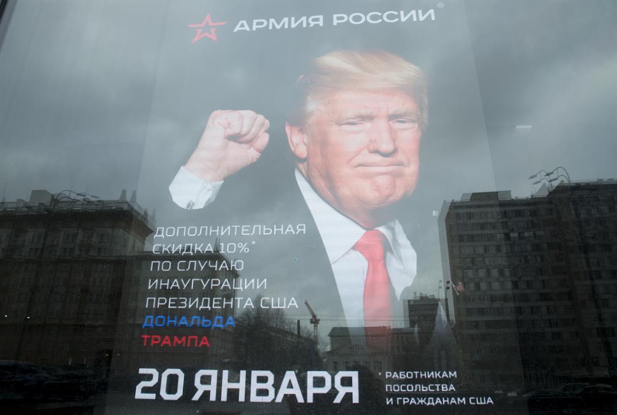 The U.S. Embassy is reflected in a window of a shop in Moscow, Russia. Jan. 20, 2017. The poster reads: “10 percent discount to the embassy employees and US citizens on the Inauguration Day”. (AP Photo/Pavel Golovkin)