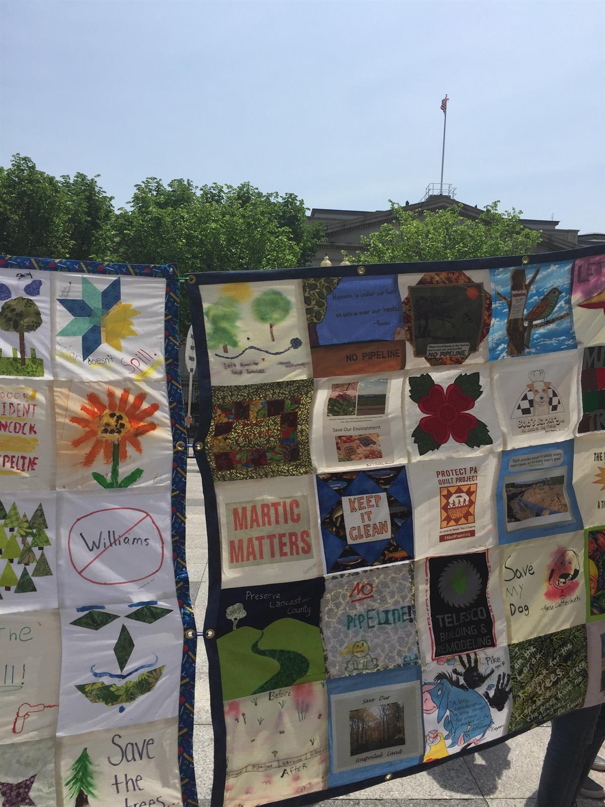 A large quilt depicting different climate slogans.