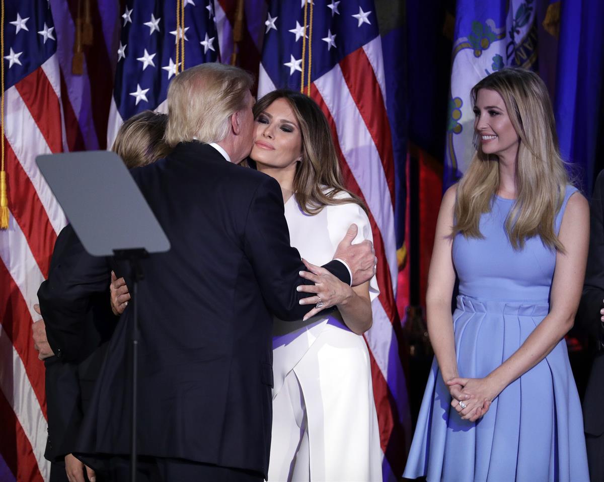 Donald Trump kisses his wife Melania Trump as his daughter Ivanka Trump watches after giving his acceptance speech during his election night rally, Wednesday, Nov. 9, 2016 (AP Photo/John Locher)