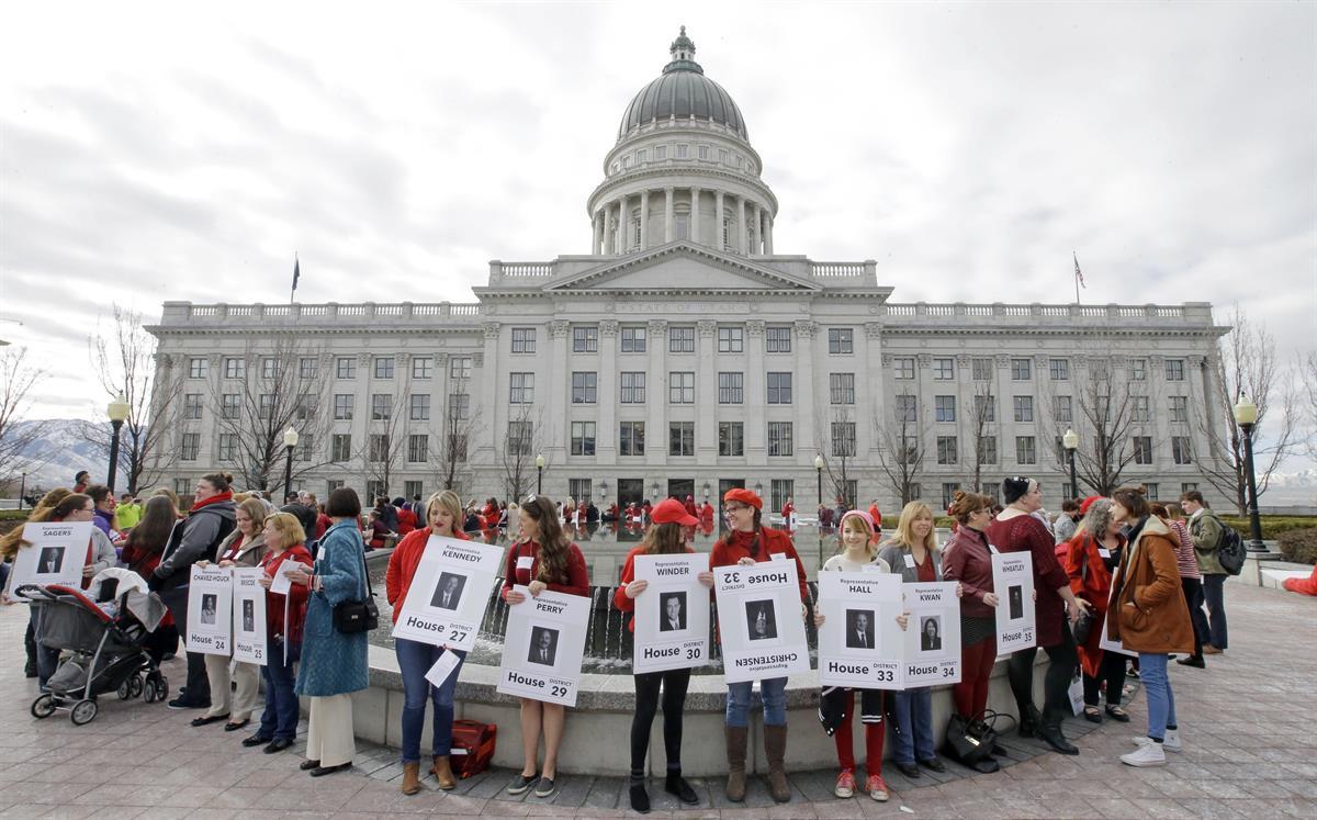 Women holding signs with photos of their local lawmakers gathered at the Utah state capitol for a Day Without a Woman protest — March 8, 2017, in Salt Lake City. (AP Photo/Rick Bowmer)
