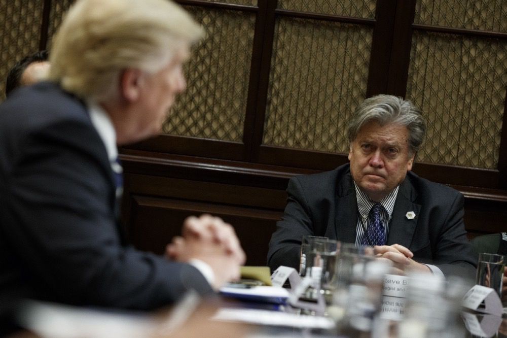 White House Chief Strategist Steve Bannon stares at President Donald Trump during a meeting in the Roosevelt Room of the White House in Washington — Tuesday, Jan. 31, 2017. (AP Photo/Evan Vucci)