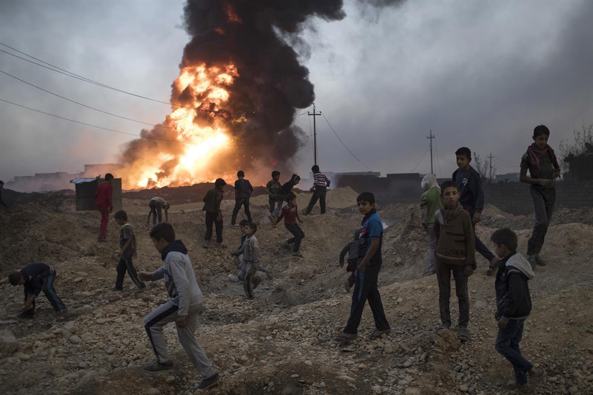 Children play next to a burning oil field in Qayyarah, Mosul— Thursday, Nov. 3, 2016. (AP Photo/Felipe Dana)