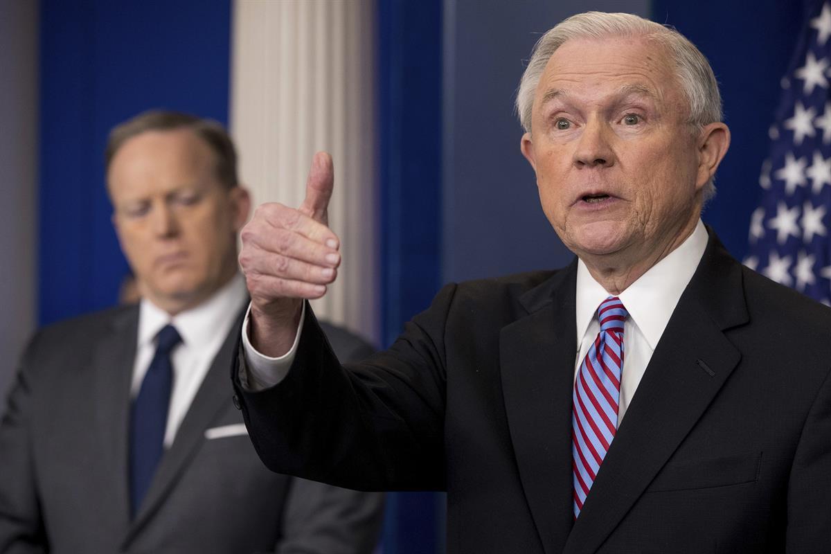 Attorney General Jeff Sessions, right, accompanied by White House press secretary Sean Spicer, talks to the media during the daily press briefing at the White House in Washington, Monday, March 27, 2017. (AP Photo/Andrew Harnik)