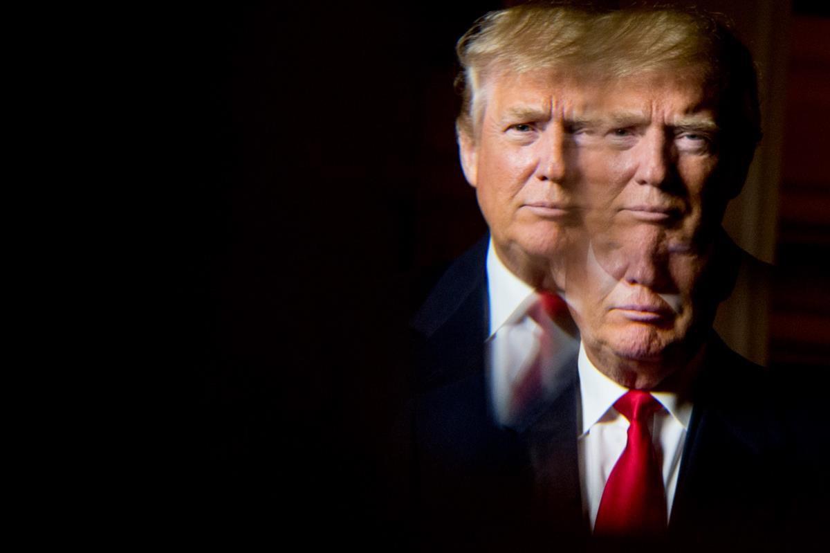 Donald Trump, seen in reflection, poses for a portrait following an interview with the Associated Press at the Trump National Golf Club in Sterling, Va., Wednesday, Dec. 2, 2015 (AP Photo/Andrew Harnik)