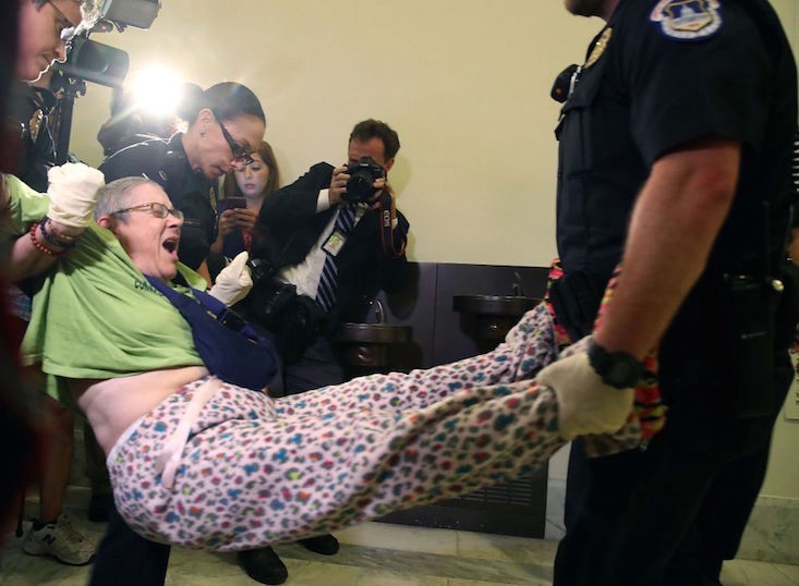 Capitol Police remove a woman participating in a disability rights protest in front of Senate Majority Leader Mitch McConnell’s office. Mark Wilson/Getty Images
