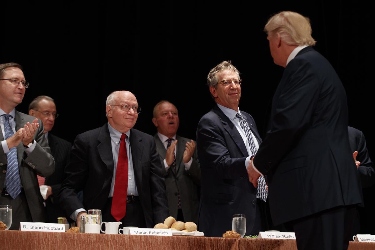 Economists, from left, R. Glenn Hubbard, left, Martin Feldstein, and William Rudin, greet then Republican presidential candidate Donald Trump as he arrives to speak at the Economic Club of New York, Thursday, Sept. 15, 2016, in New York. (AP Photo/ Evan Vucci)