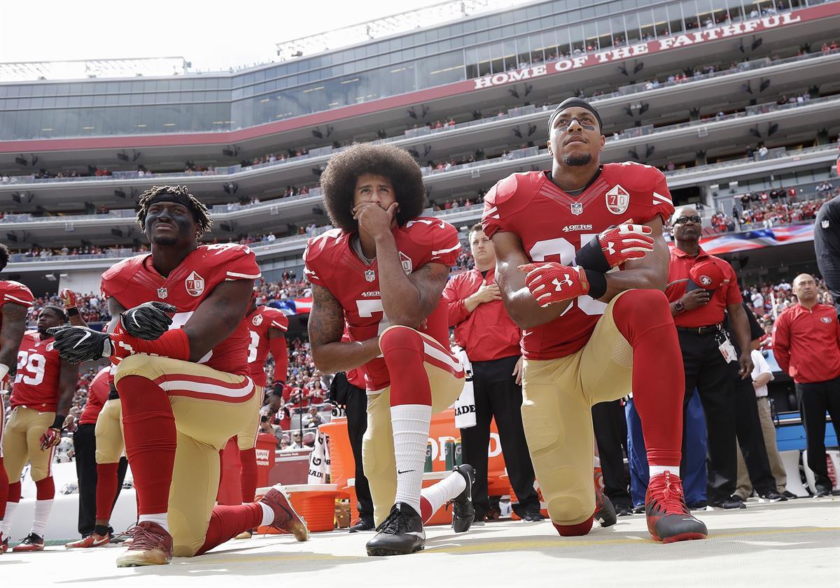 San Francisco 49ers outside linebacker Eli Harold, left, quarterback Colin Kaepernick, center, and safety Eric Reid kneel during the national anthem before an NFL football game against the Dallas Cowboys in Santa Clara, Calif., Sunday, Oct. 2, 2016. (AP Photo/Marcio Jose Sanchez)