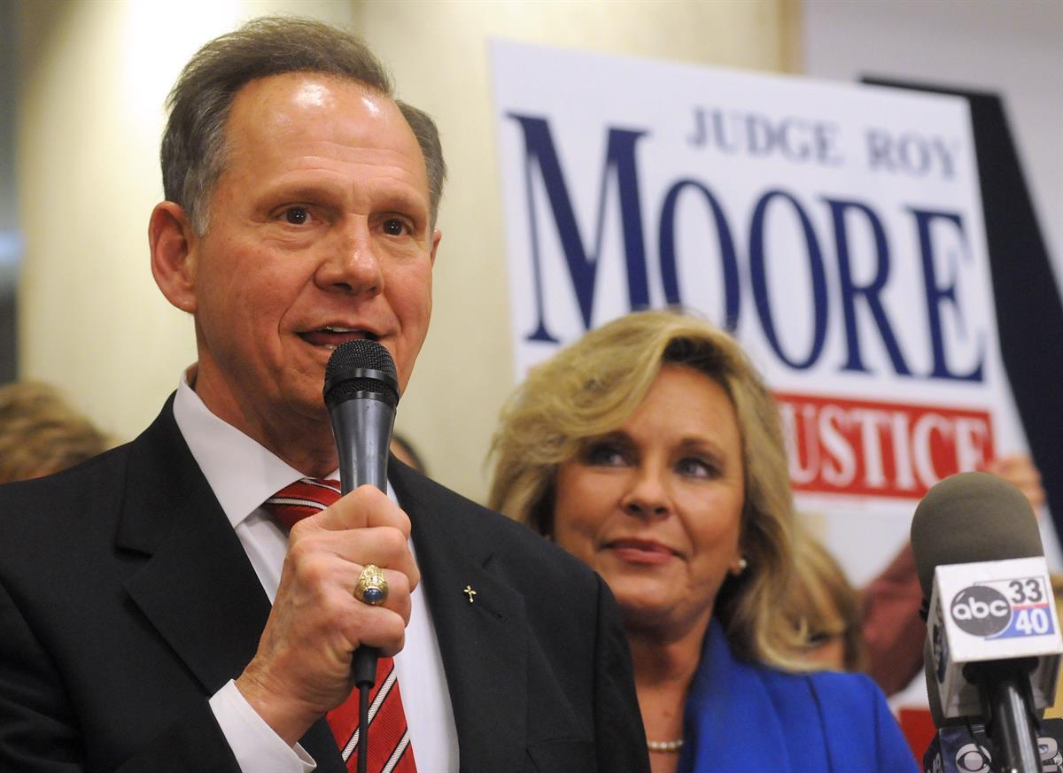 Roy Moore speaks to the audience as wife Kayla looks on at his election party in Montgomery, Ala., on election night — Nov. 6, 2012 (AP Photo/David Bundy, File)