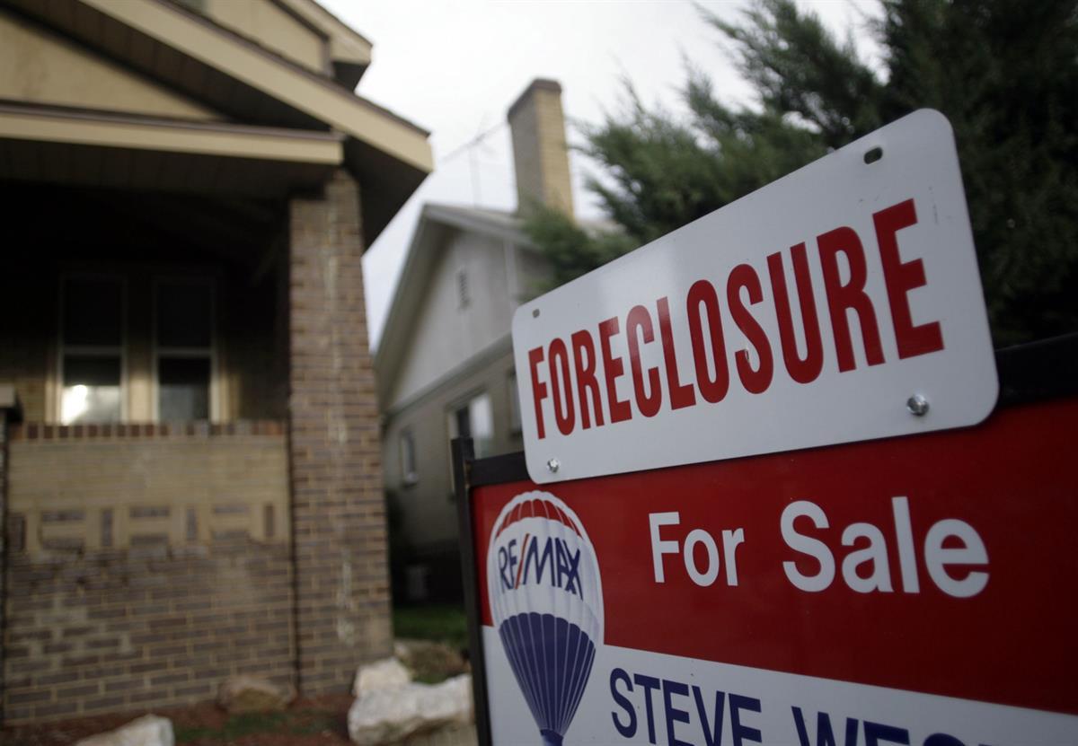 A foreclosure sign tops a sale sign outside an existing home on the market in northwest Denver — Aug. 29, 2007 (AP Photo/David Zalubowski, file)