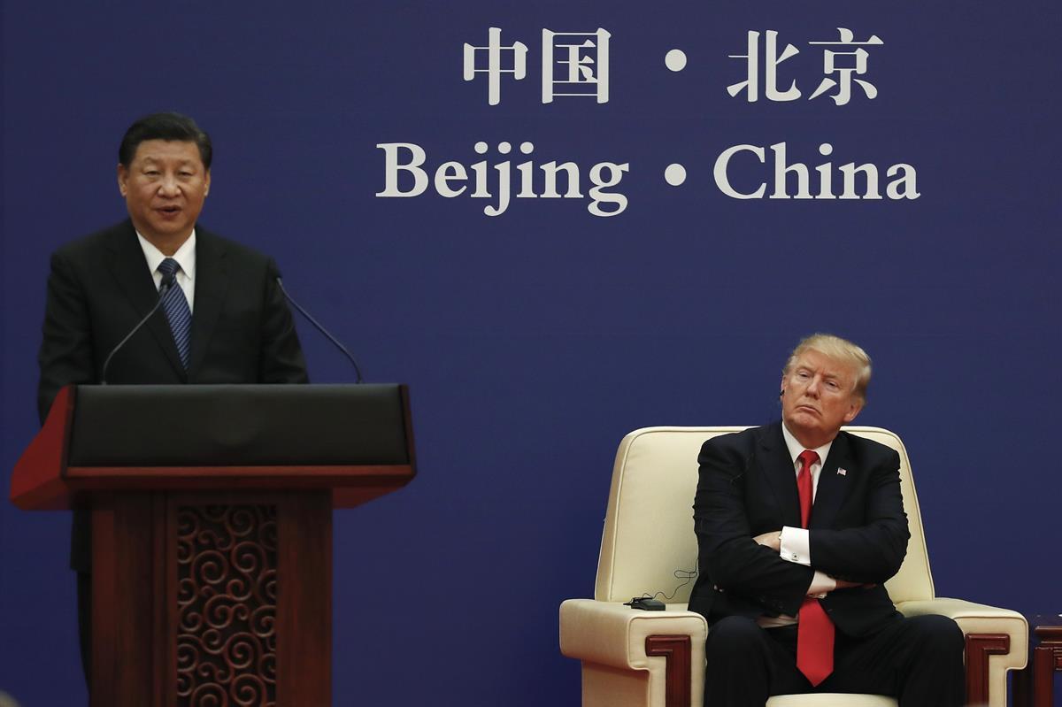 U.S. President Donald Trump listens to a speech by Chinese President Xi Jinping during a business event at the Great Hall of the People in Beijing — Nov. 9, 2017 (AP Photo/Andy Wong)